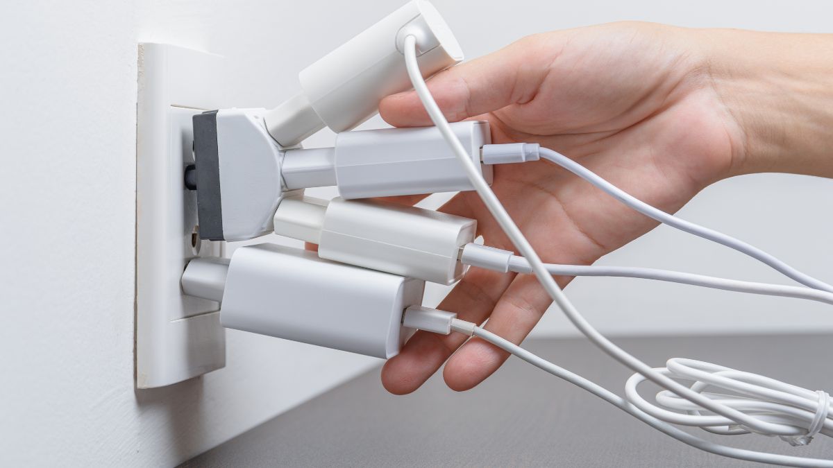 3 electrocasnice care îți consumă curent și când dormi. În imagine: mână pe ștechere priză