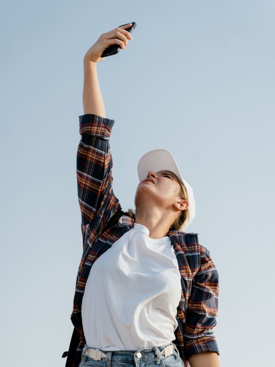 Foto: O persoană caută semnal pentru telefonul mobil, cu mâna întinsă