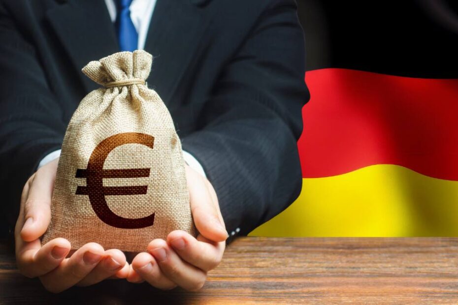 Miliardarii germani se înmulțesc. Foto: barbat cu un sac de euro, pe fondul unui drapel german