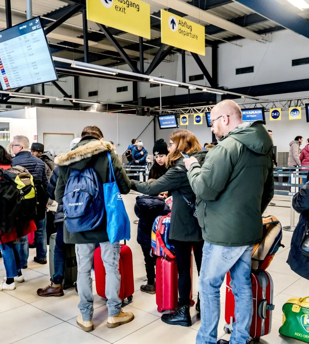 Bagajul de mână inclus în tariful afișat inițial. În imagine: persoane la coadă la check in în aeroport