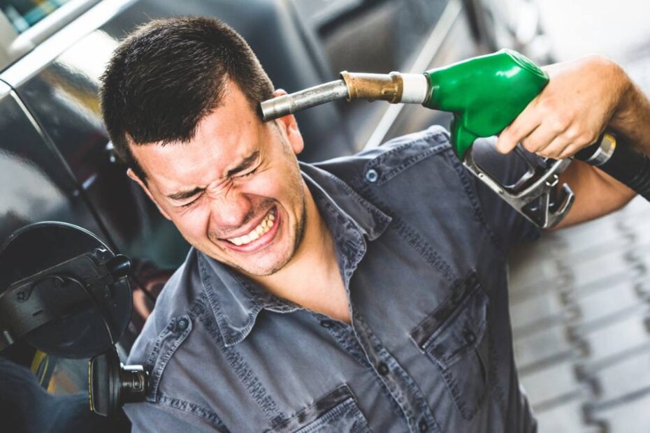 Motorina se scumpește puternic Germania. În imagine, un șofer cu pompa de carburant la tâmplă