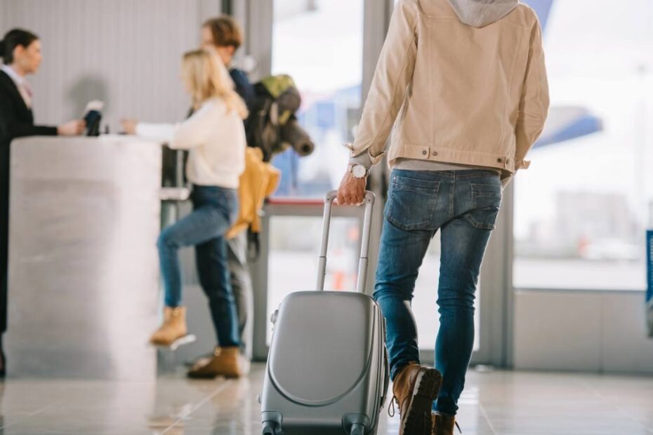 Noi drepturi ale pasagerilor în UE. În imagine, un bărbat în aeroport care trage după el un troler