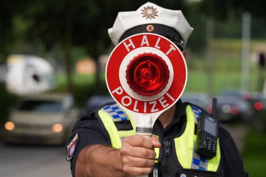 controale rutiere Germania august 2026. În imagine, un polițist cu o paletă de oprire în dreptul feței