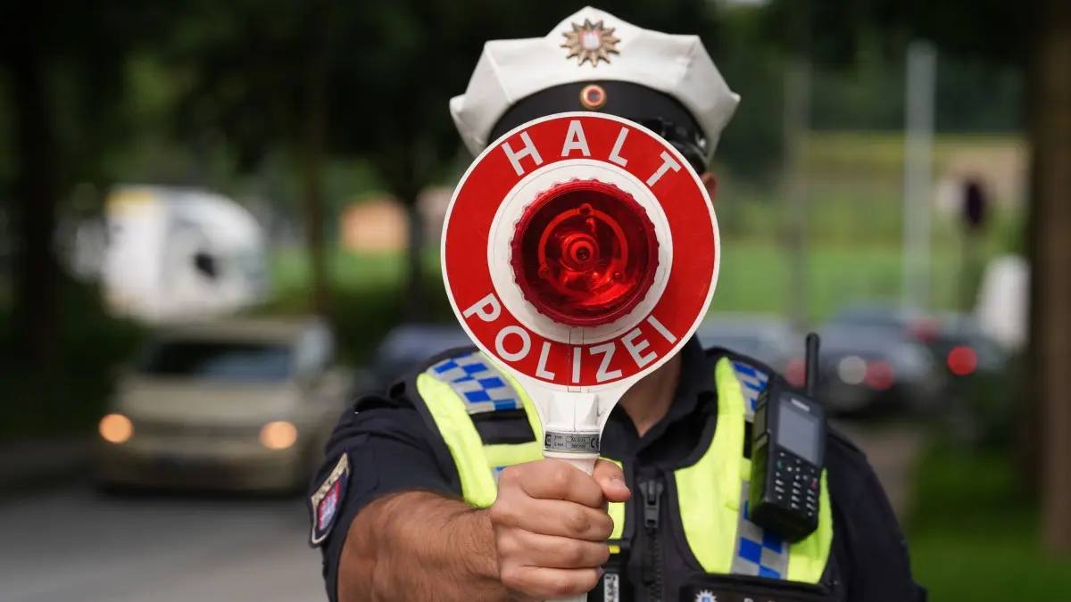 controale rutiere Germania august 2026. În imagine, un polițist cu o paletă de oprire în dreptul feței