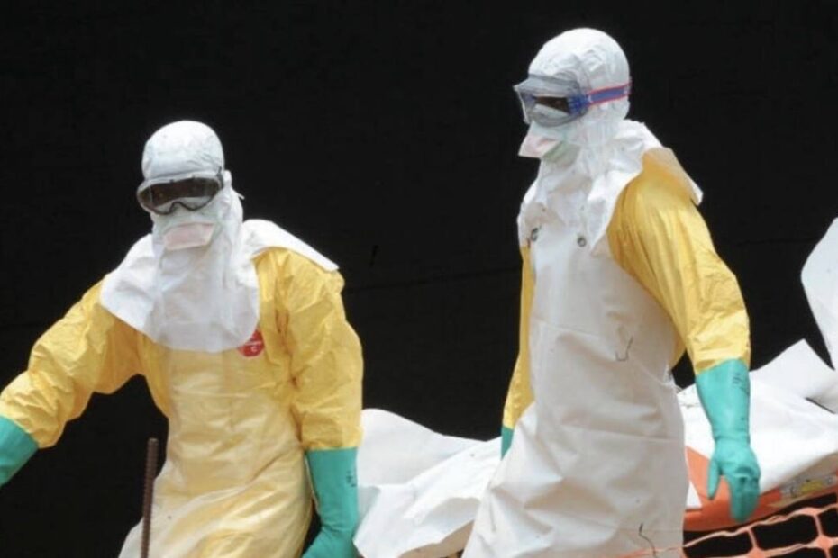 Epidemia de Ebola se agravează. În imagine, personal sanitar în costume de protecție transportă o persoană infectată