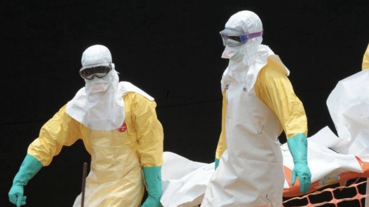 Epidemia de Ebola se agravează. În imagine, personal sanitar în costume de protecție transportă o persoană infectată