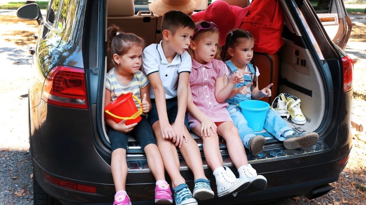 Români opriți pe autostrada A3 în Germania: aveau copii în portbagaj. Imagine ilustrativă cu patru copii în portbagajul unei mașini