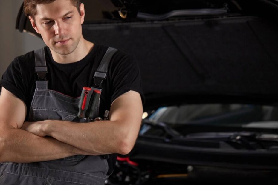 Industria auto germană se află în dificultate. În imagine, un muncitor pesimist lîngă o mașină