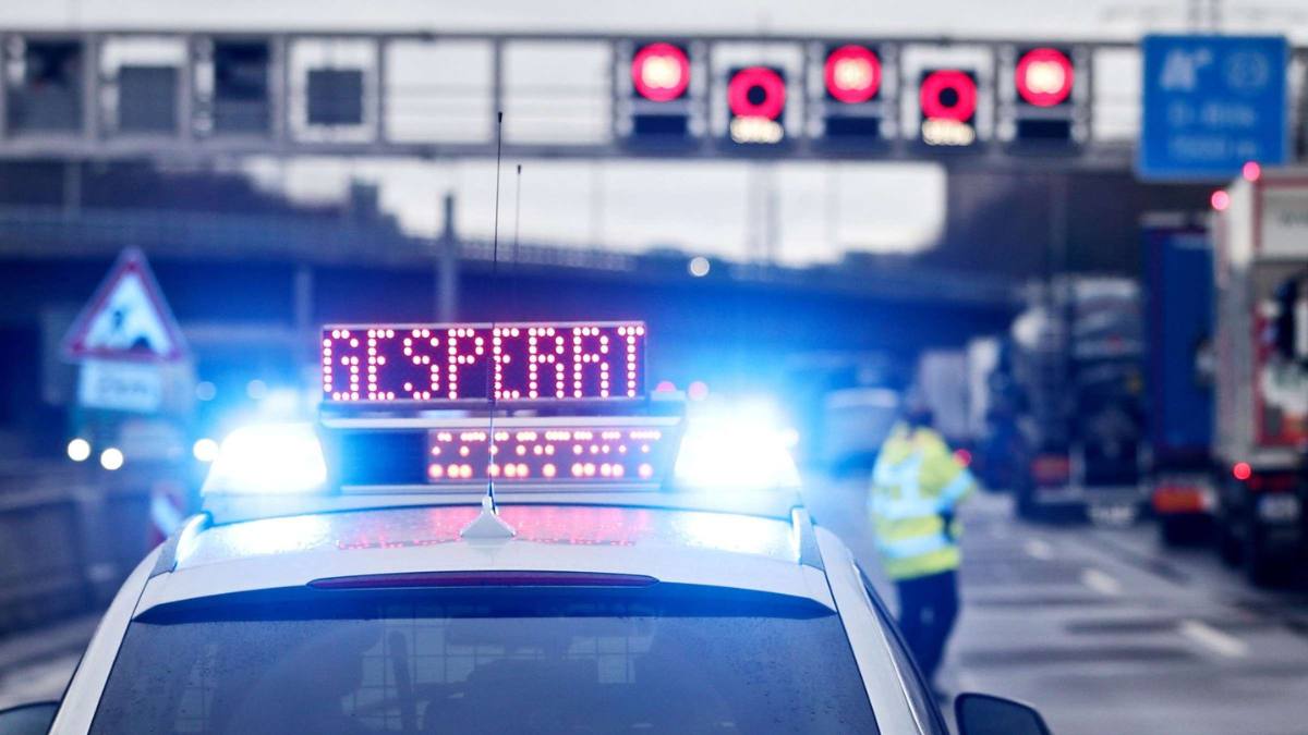 Mașină de poliție cu lumini albastre și mesajul GESPERRT pe o autostradă închisă, imagine generică