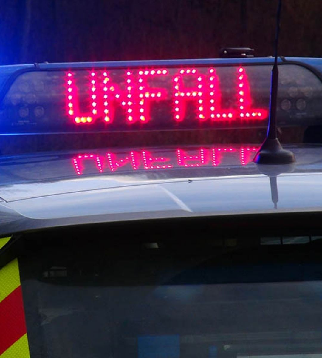 Panou luminos cu mesajul UNFALL pe o mașină de poliție germană, imagine generică de accident
