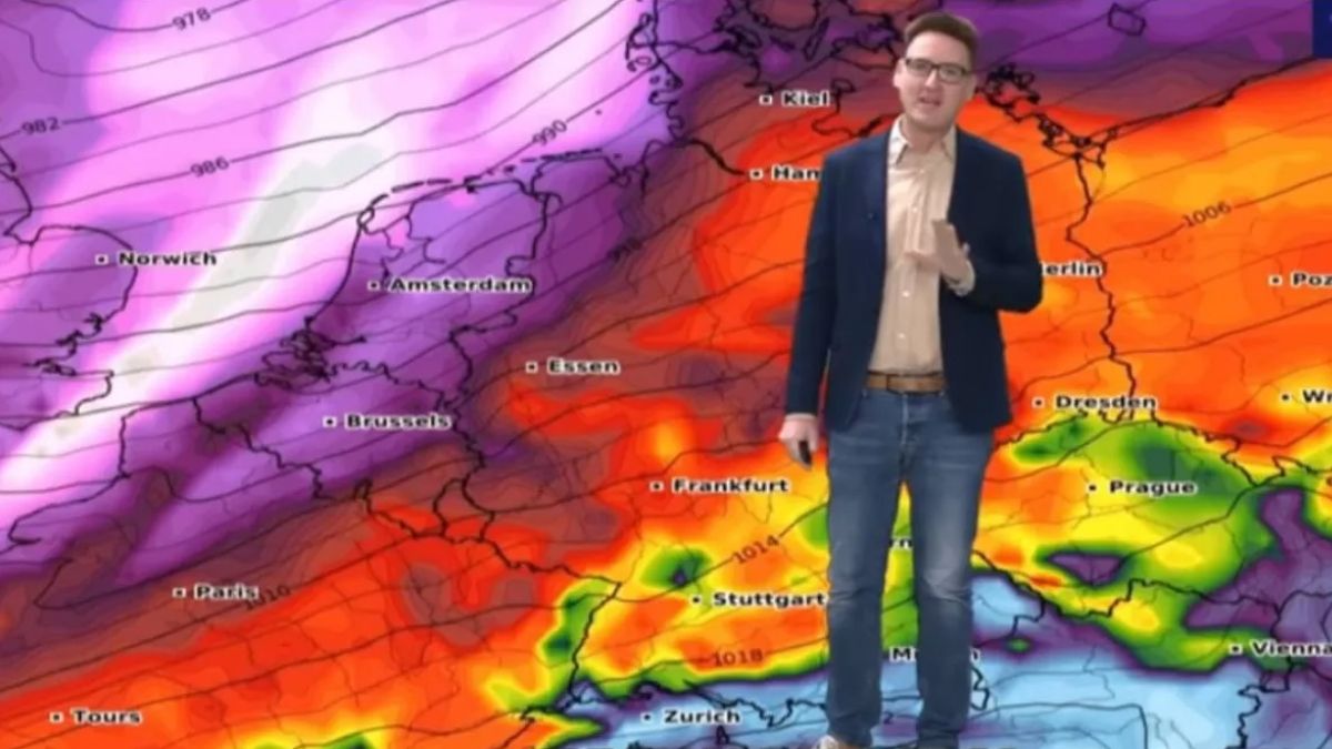 Prezentator meteo în fața unei hărți cu sisteme de furtună deasupra Germaniei și Europei