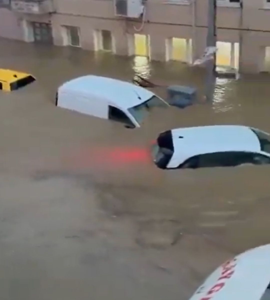 Autoturisme aproape complet scufundate în apele inundațiilor din Istanbul, în apropierea unor clădiri.
