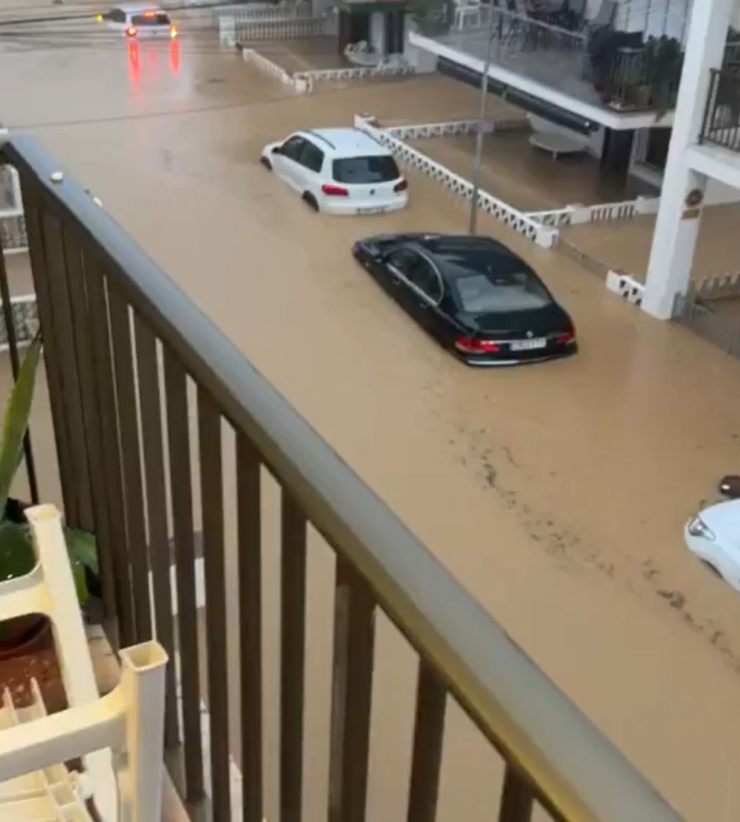 Mașini parțial scufundate pe o stradă inundată, văzute de la balcon, în Spania