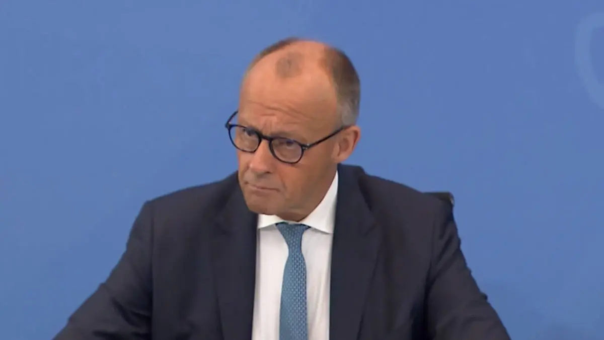 Friedrich Merz, în costum închis și cravată albastră, în timpul unei intervenții publice