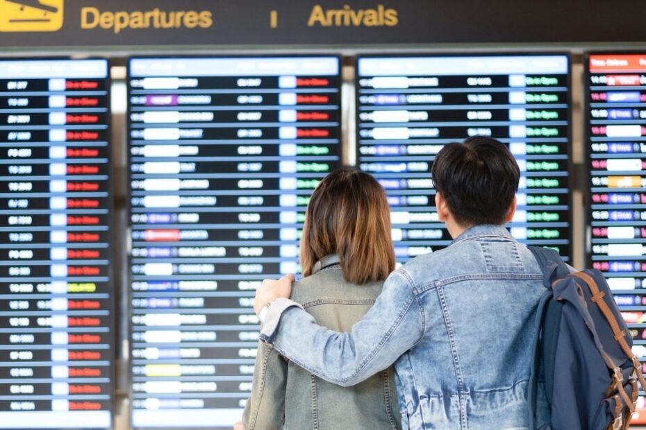 Pasageri într-un aeroport, în fața panourilor de plecări și sosiri – noile drepturi pentru călătoriile cu avionul în UE