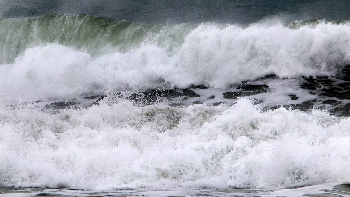 Valuri uriașe se sparg cu putere în ocean, formând spumă albă, imagine ilustrativă pentru fenomenul climatic El Niño.