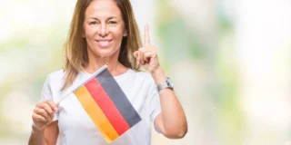 Schimbări august 2026 Germania și UE. În imagine, o femeie cu steagul Germaniei în mână