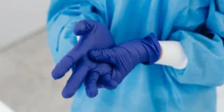 OMS avertizează Europa cu privire la virusul mortal. }n imagine, un medic își pune mănușile