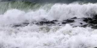 Valuri uriașe se sparg cu putere în ocean, formând spumă albă, imagine ilustrativă pentru fenomenul climatic El Niño.