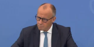 Friedrich Merz, în costum închis și cravată albastră, în timpul unei intervenții publice